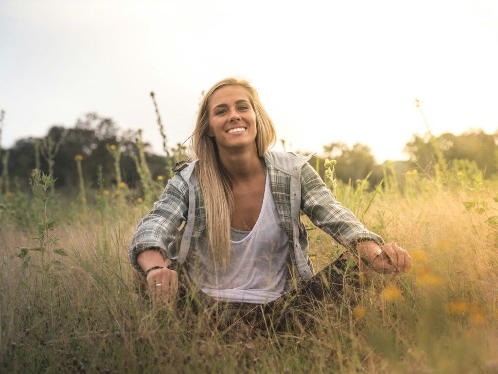 Woman sitting in nature practicing Ayurveda lifestyle grounding and body balance