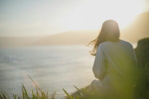 Woman meditating outdoors practicing mindfulness for stress relief and emotional balance